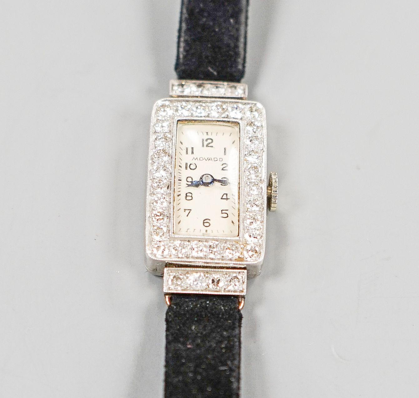 A lady's 950 white meta l(platinum?) and diamond set Movado manual wind wrist watch, on a later fabric strap, gross weight 15.2 grams.